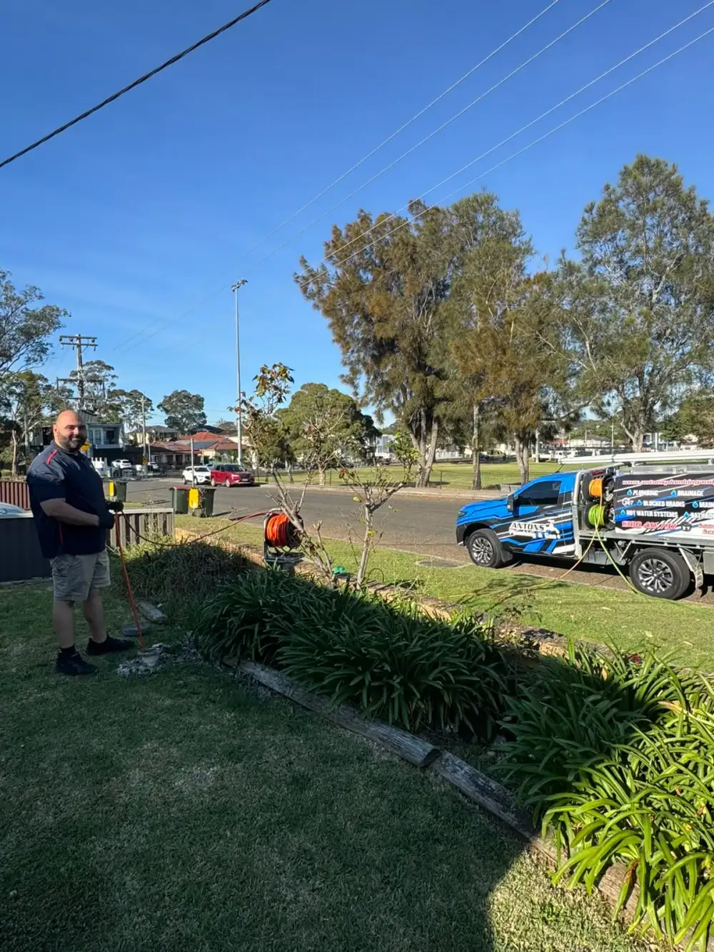 Antons plumber with a drain hose in a garden beside the service vehicle