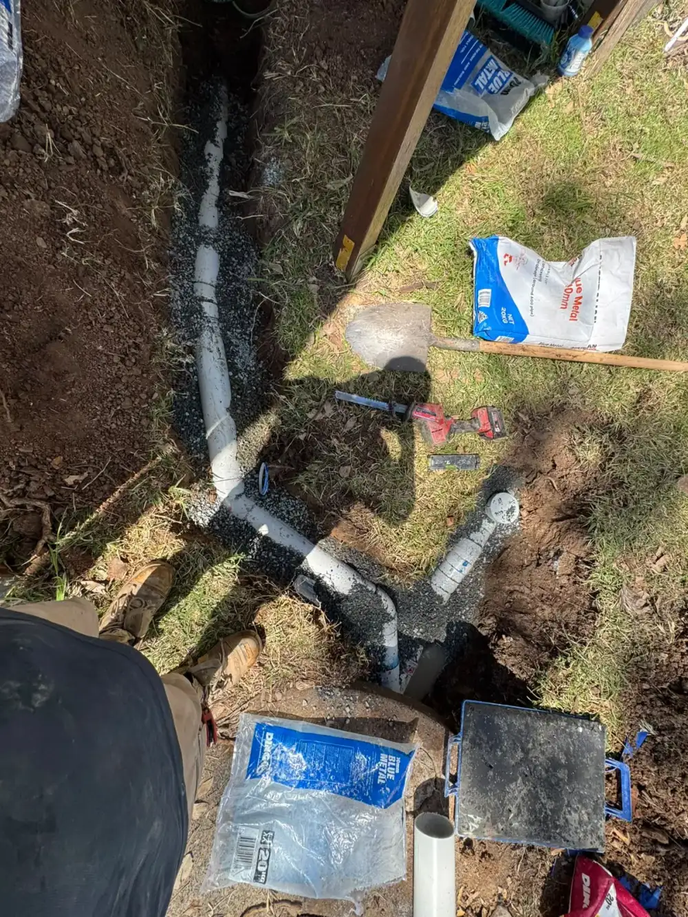 Replacement drainage junction and access pipe in an excavated garden trench