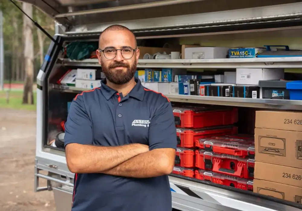 Plumber beside a stocked service vehicle