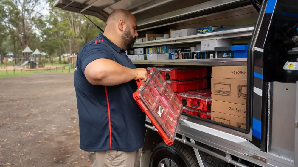 Antons plumber retrieving a fittings case from a stocked service vehicle