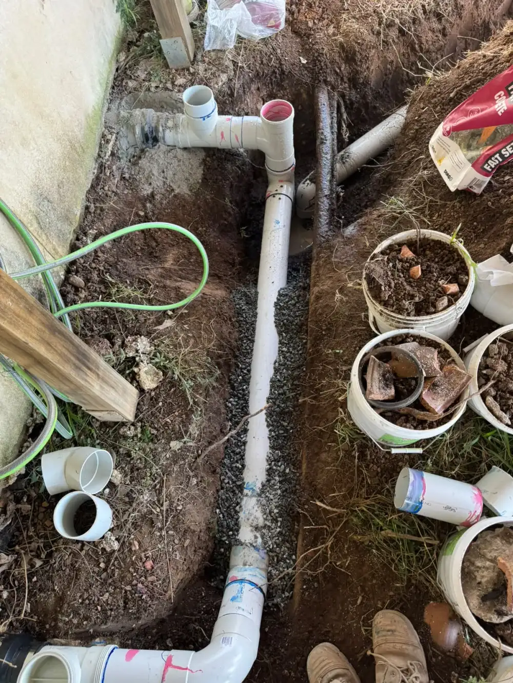 New drainage pipework and junctions laid beside a house wall